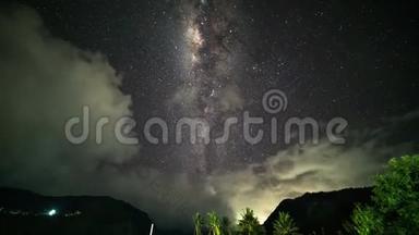 夜晚的风景随着五颜六色的银河和多云的光线在山上流逝。 带热带山脉的星空